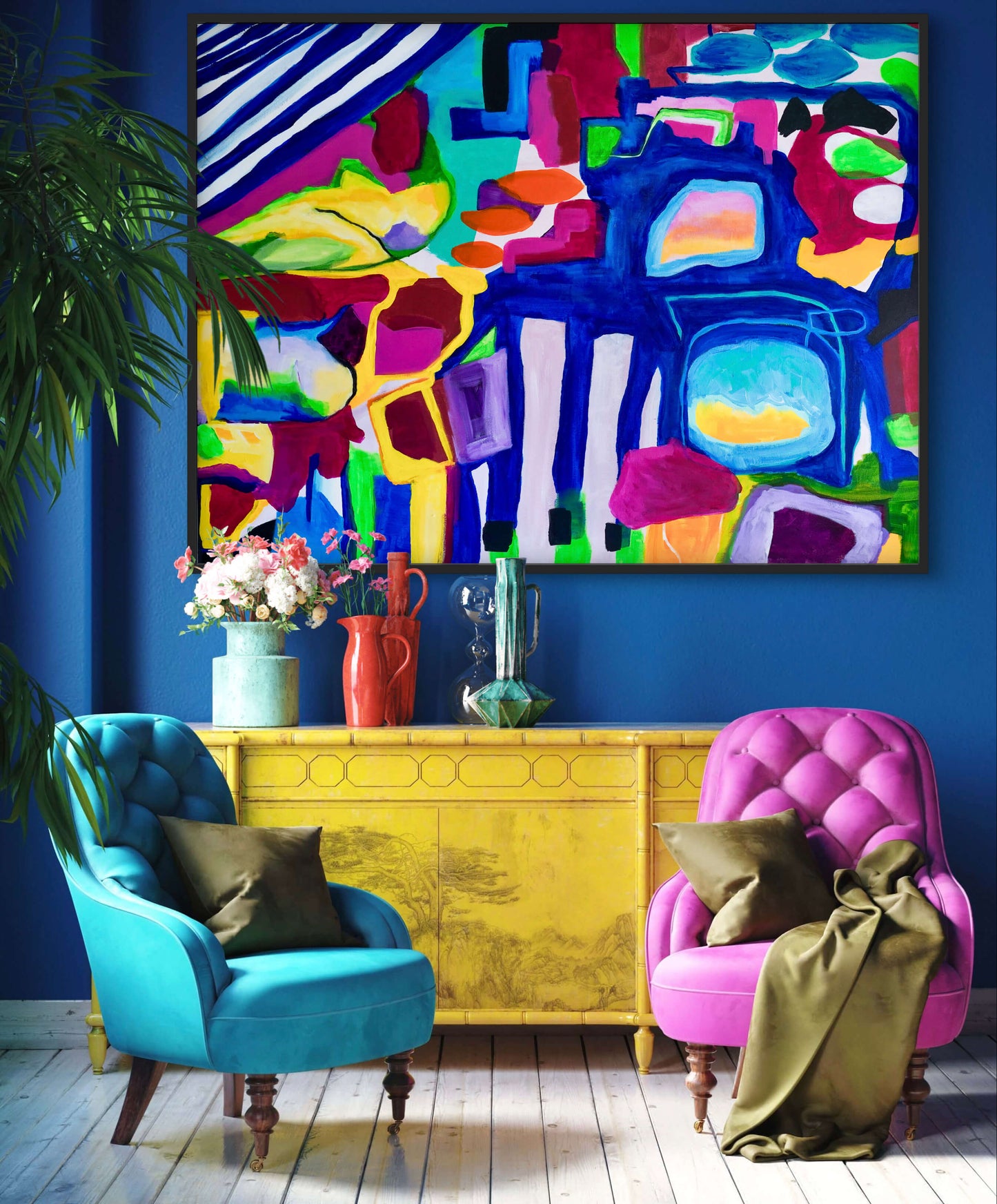 Colorful abstract painting above a yellow console table with two chairs in a room.