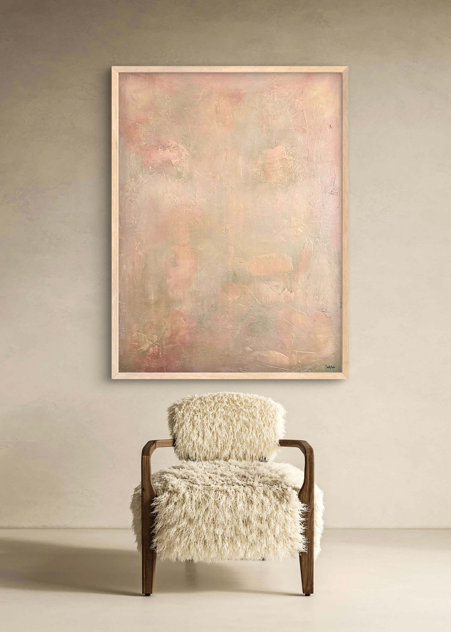Furry armchair in front of a large abstract painting on a beige wall.