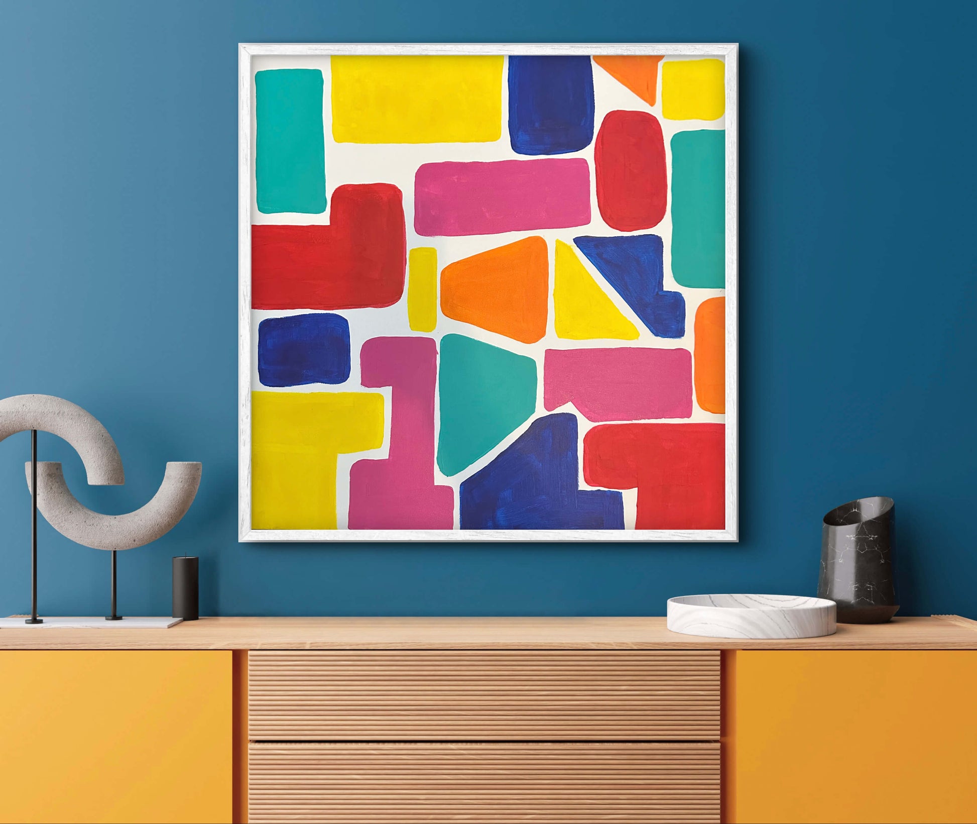 Colorful abstract art piece on a blue wall above a wooden cabinet.