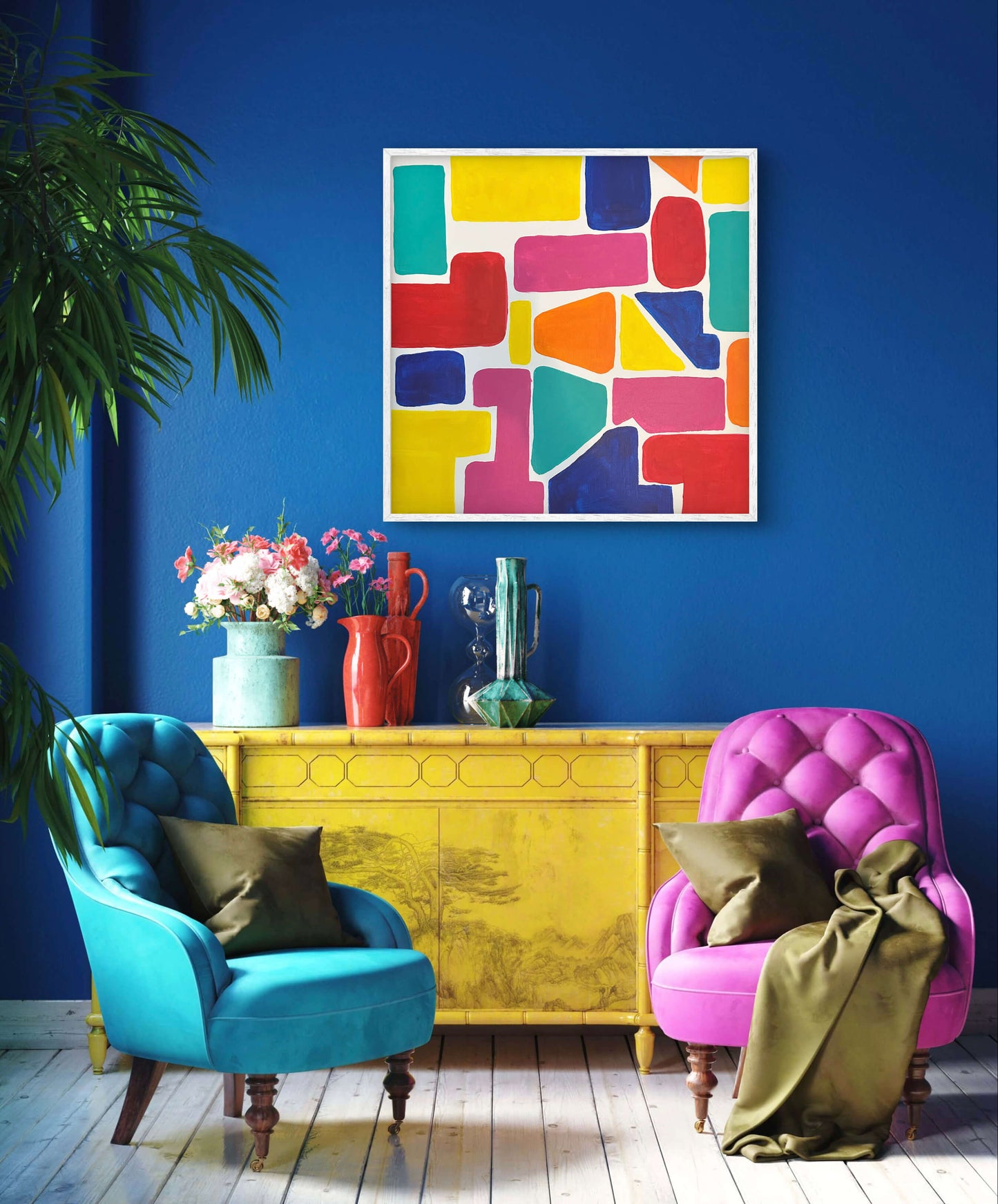 Colorful abstract art piece on a blue wall above a yellow console table with two armchairs.