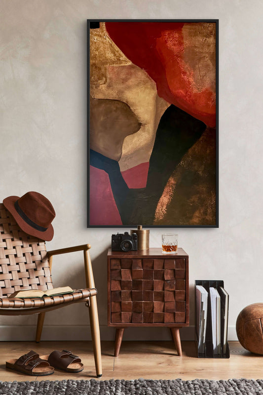 Abstract art piece on a wall above a wooden side table with a chair and decor items.